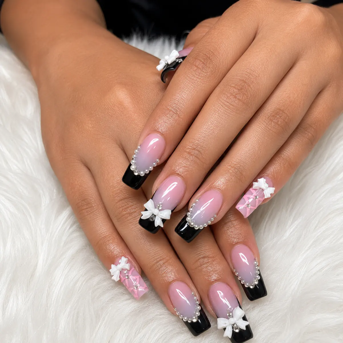 Pink and black nails with pearl and bow details